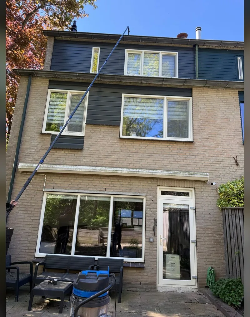 Een woning wordt met een telescopische steel vanaf de grond gereinigd tot aan de dakgoot